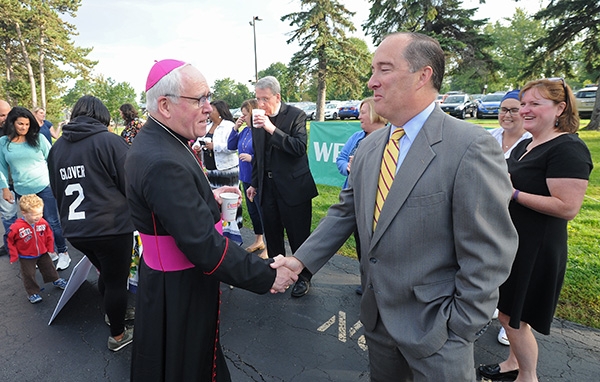 Bishop Richard Malone shakes hands with Dennis Schaeffer, who has two children attending class, on the first day of school at St. Joseph University School students on Main Street, Buffalo. Parents were treated to coffee and donuts as students made their way into the school. (Dan Cappellazzo/Staff Photographer)
